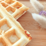 deux gaufres cheddar- jambon de poulet sur une planche en bois